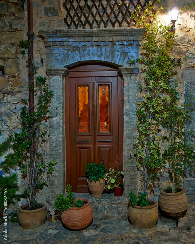 Night view of a house entrance, wood and glass door. Mesta town, Chios island, Greece.