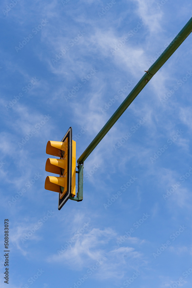 Sygnalizacja świetlna, żółty semafor na tle niebieskiego nieba. - obrazy, fototapety, plakaty 