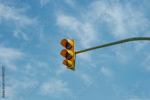 Sygnalizacja świetlna, żółty semafor na tle niebieskiego nieba. photo