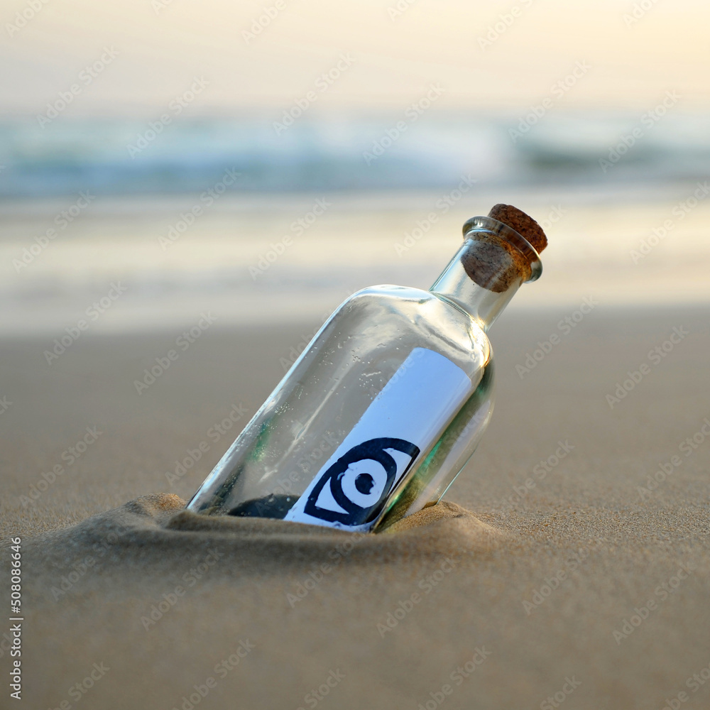Símbolo de ojo en una botella encontrada en la playa. Mensaje esotérico. Concepto sin privacidad. Símbolo de ojo en una botella encontrada en la playa. Mensaje esotérico. Concepto sin privacidad.