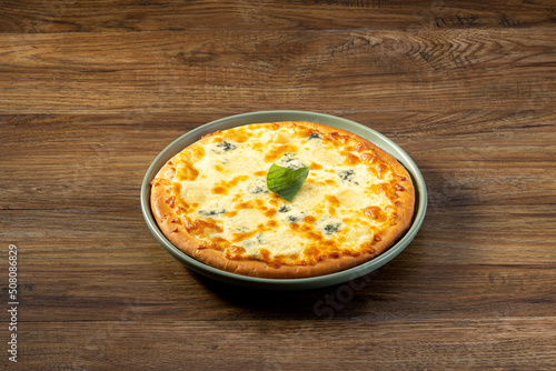 Quattro Formaggi Pizza served in a dish top view on dark wooden background