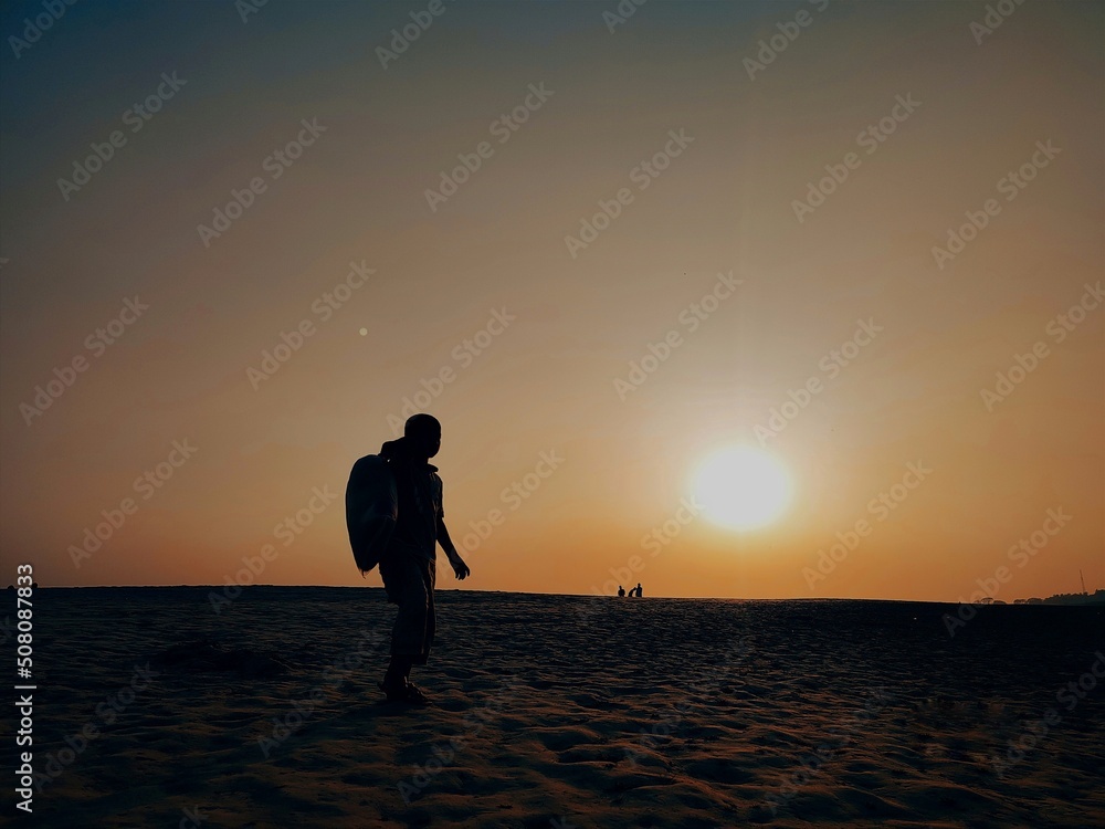 Man walking on sunset background 