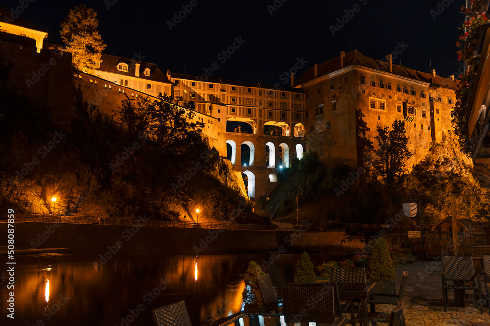 Night view of Cesky Krumlov Castle and the Cloak bridge from the banks of Vltava river. Spectacular renaissance and baroque chateau and castle in Cesky Krumlov, South Bohemia, Czech Republic.