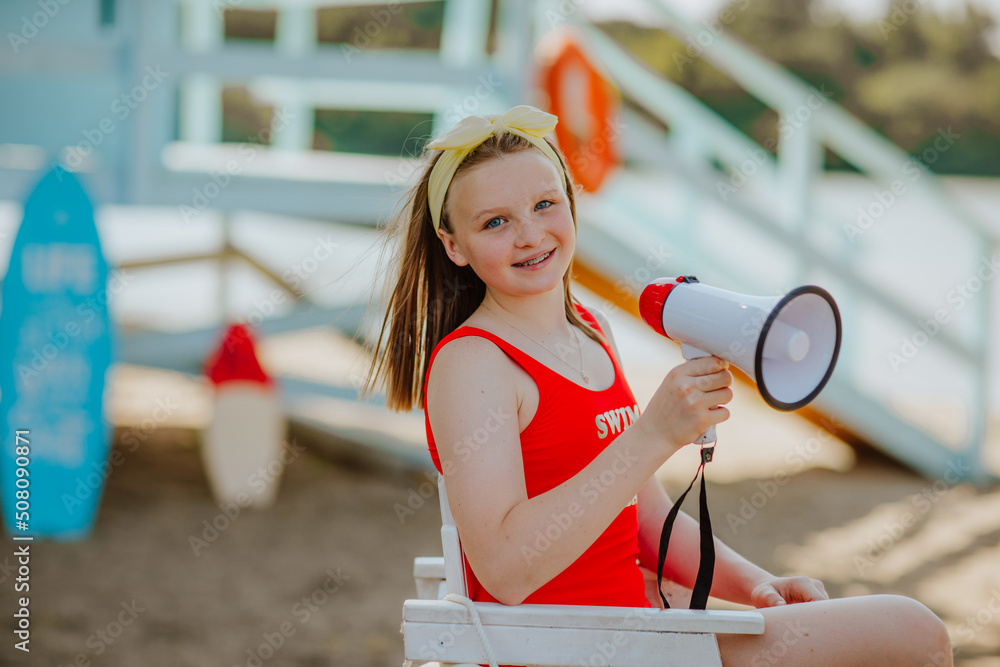 Girl in red bikini posing with megaphone sitting on summer chair at the ...