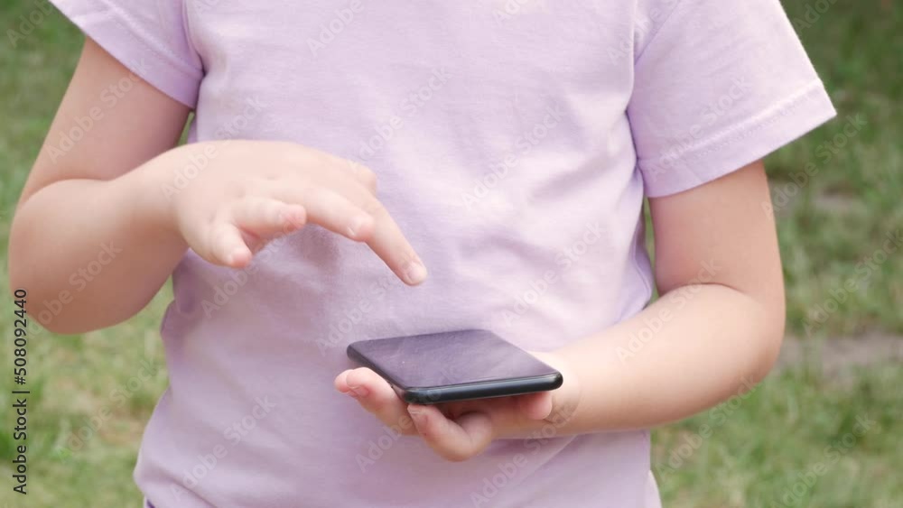 Anonymous young girl, school age child using her smartphone, hands closeup, playing around on her mobile phone, one single finger tapping the screen, outdoors scene, detail, children and technology Anonymous young girl, school age child using her smartphone, hands closeup, playing around on her mobile phone, one single finger tapping the screen, outdoors scene, detail, children and technology