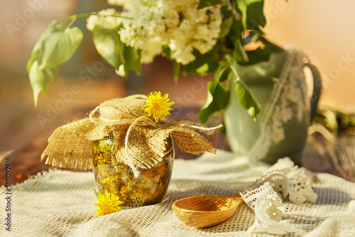 Homemade herbal organic dandelion tincture with wild flowers. Dandelion root tincture recipe.Homemade homeopathy alternative medicine. Natural essence