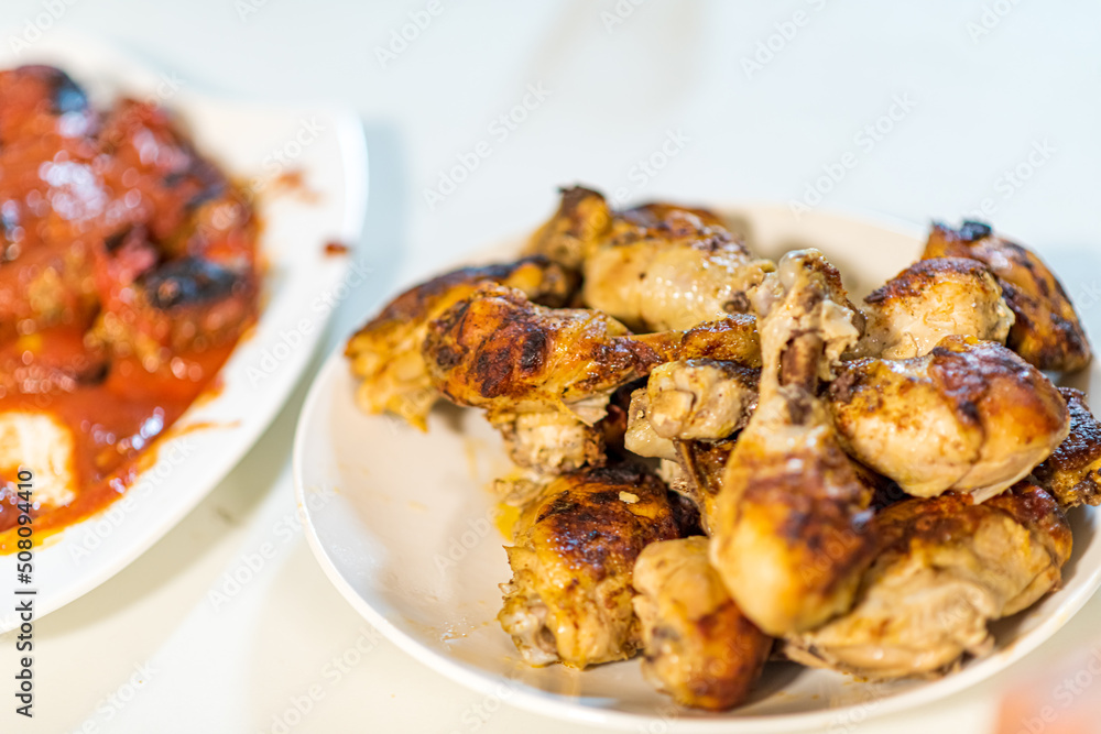 Chicken shanks, chicken legs are served on a plate with various salad plates in the background. High quality photo
