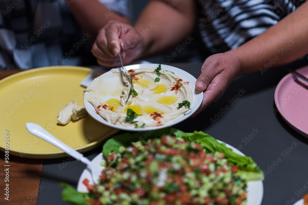 People eat together. A table set with delicacies from the Arab cuisine. Chickpeas, salads, pitas, stuffed vegetables, meat and chicken. High quality photo. High quality photo People eat together. A table set with delicacies from the Arab cuisine. Chickpeas, salads, pitas, stuffed vegetables, meat and chicken. High quality photo. High quality photo
