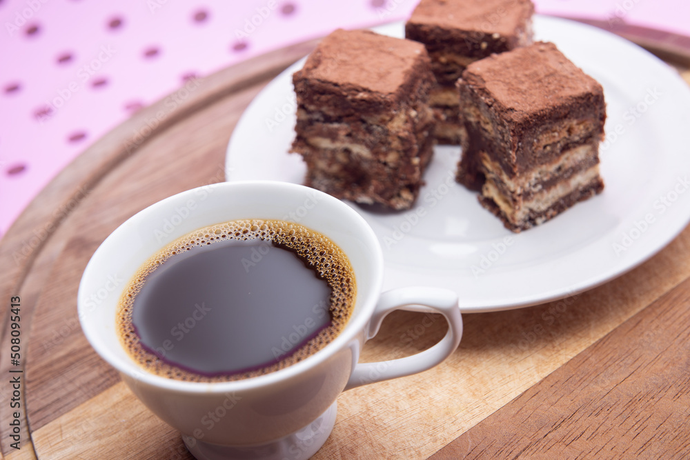 Uma xícara com café e palha italiana sobre madeira, sobre superfície cor-de-rosa. Uma xícara com café e palha italiana sobre madeira, sobre superfície cor-de-rosa.