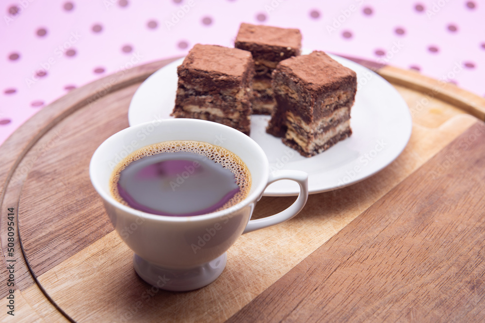 Uma xícara com café e palha italiana sobre madeira, sobre superfície cor-de-rosa. Uma xícara com café e palha italiana sobre madeira, sobre superfície cor-de-rosa.
