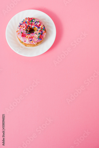 pink sprinkle donut on white plate