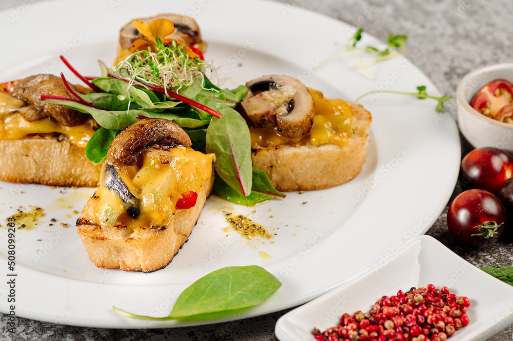 Snack of toasted bread with melted cheese and mushrooms on concrete background Snack of toasted bread with melted cheese and mushrooms on concrete background