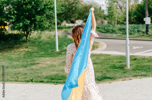 Girl with the flag of Ukraine. Ukrainian woman with the flag of Ukraine. Flag of Ukraine. Patriotic photo of a Ukrainian woman with the flag of Ukraine