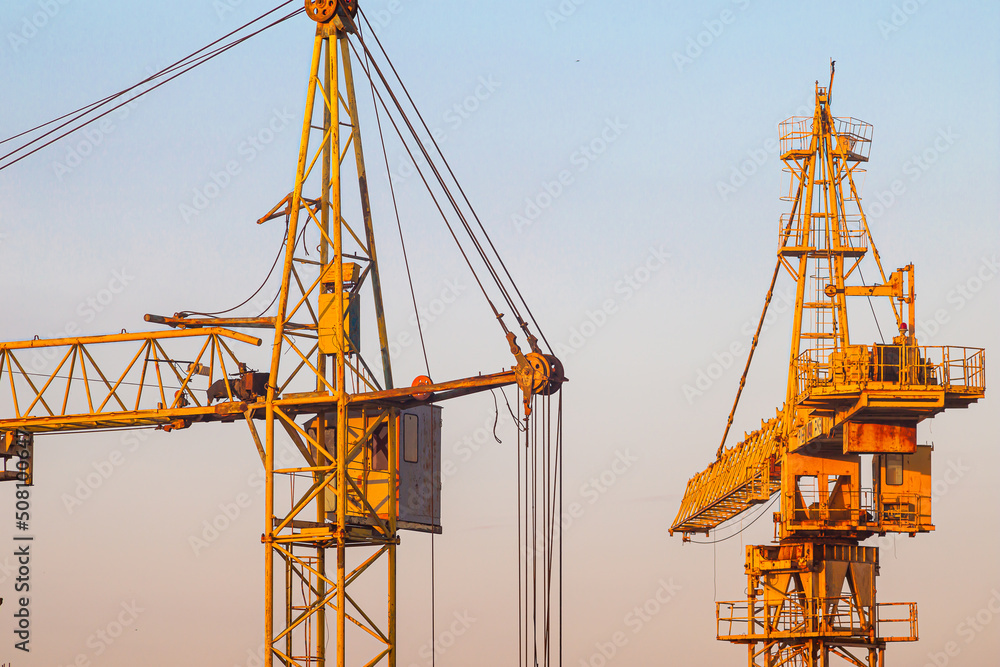 Tower cranes with hydraulic boom lift. Tower cranes on the construction of a new residential building. Tower cranes with hydraulic boom lift. Tower cranes on the construction of a new residential building.
