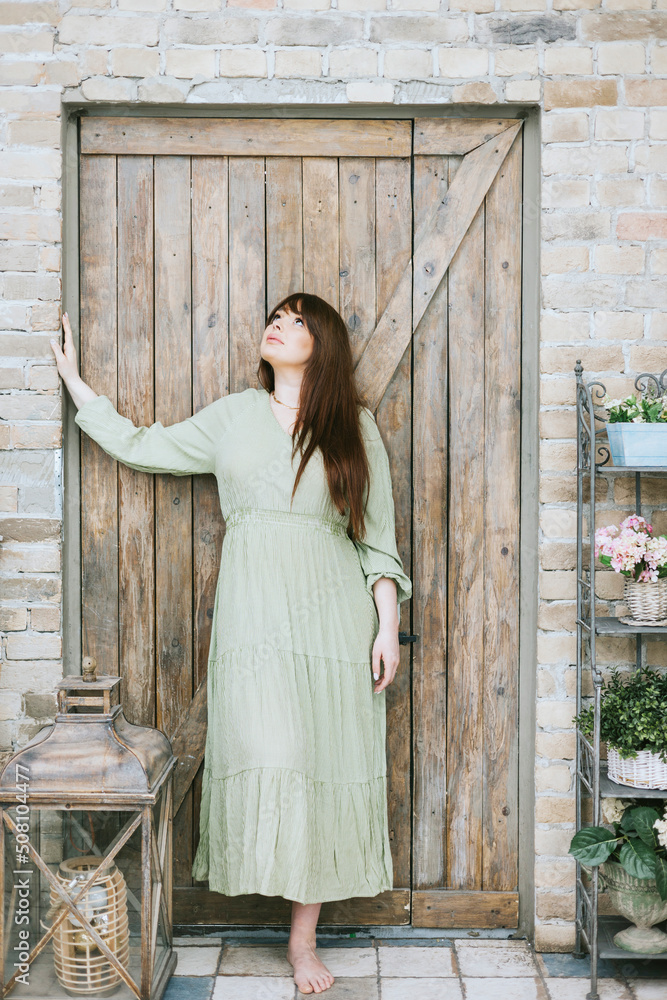 young woman plus size model in long green summer dress in greenhouse with plants and potted flowers, spring concept of urban and home jungles, place for rest and relaxation for mental health young woman plus size model in long green summer dress in greenhouse with plants and potted flowers, spring concept of urban and home jungles, place for rest and relaxation for mental health