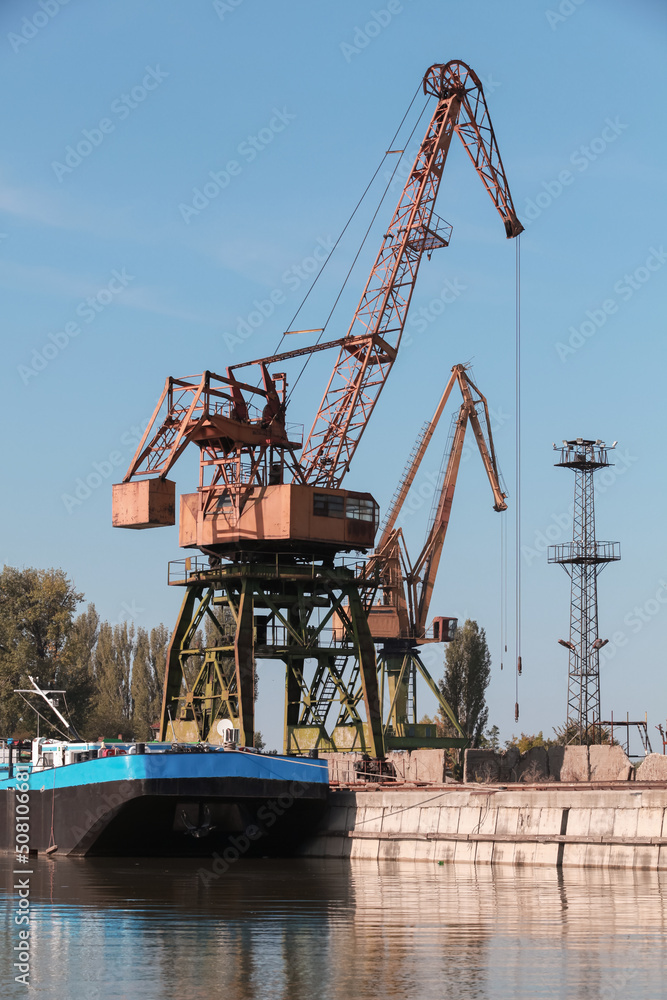 Port crane works on the river coast Port crane works on the river coast
