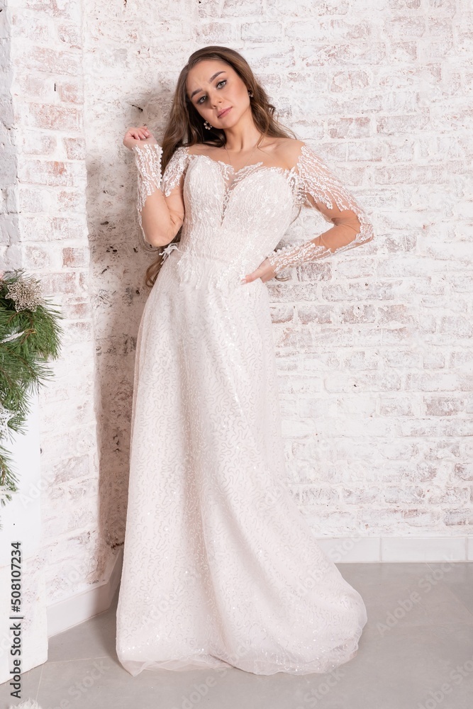 Bride in a white dress against a brick wall. Bride in a white dress against a brick wall.
