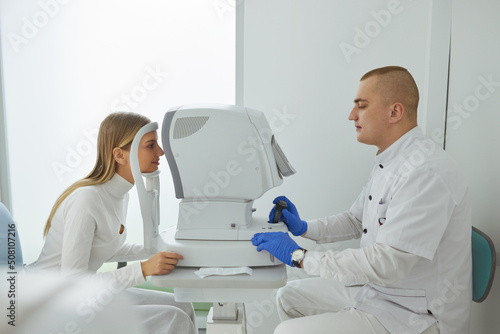 Eye Test. Optometrist Testing Woman Eyesight On Modern Equipment. Side View of Optometrist Giving Examination of the Eyes in Ophthalmology Clinic
