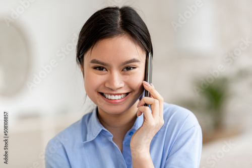 Happy attractive chinese woman having phone conversation