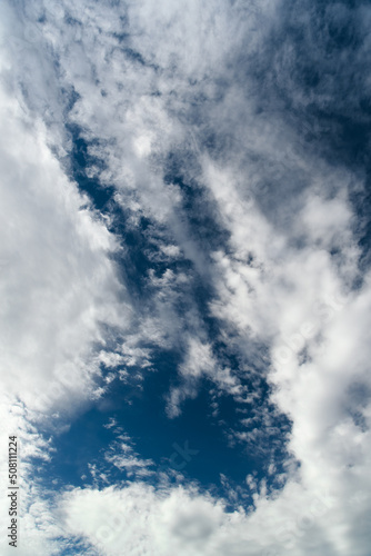 Obraz na płótnie Blue sky with cumulus white clouds. Beautiful cloudscape. Abstract background. Vertical orientation. w salonie