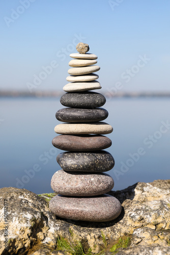 Stack of stones on rock near sea. Harmony and balance concept