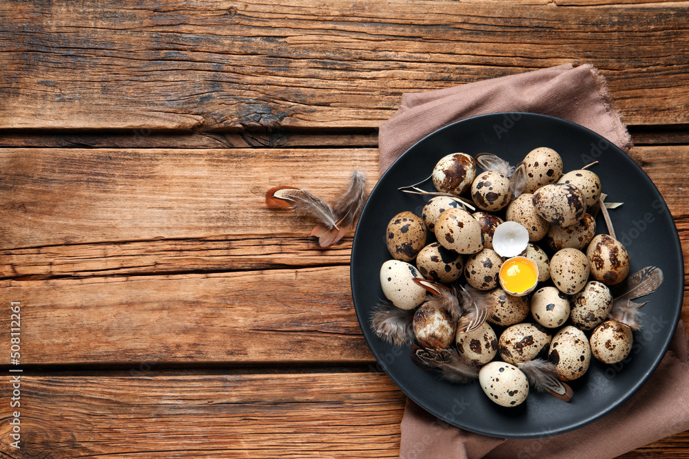 Plate with quail eggs on wooden table, top view. Space for text Plate with quail eggs on wooden table, top view. Space for text