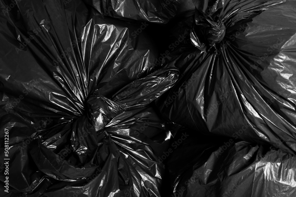 Black trash bags full of garbage as background, top view Black trash bags full of garbage as background, top view