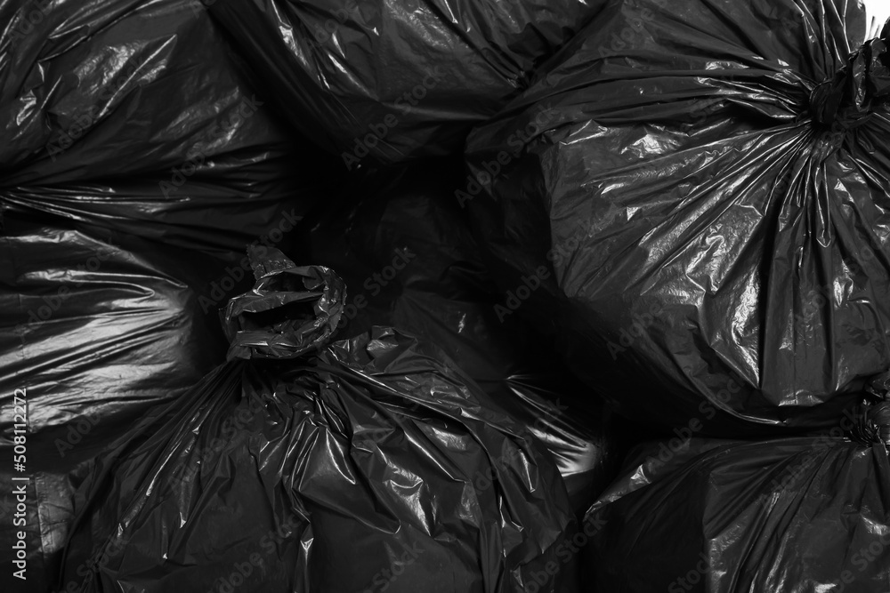 Black trash bags full of garbage as background, top view Black trash bags full of garbage as background, top view