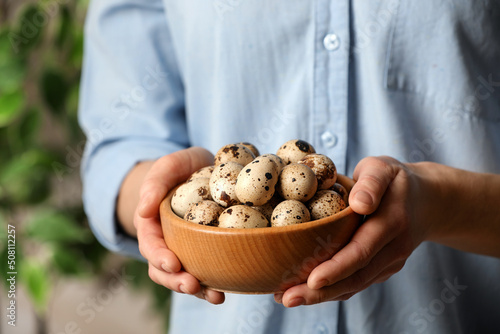 Woman with bowl of quail eggs indoors  closeup
