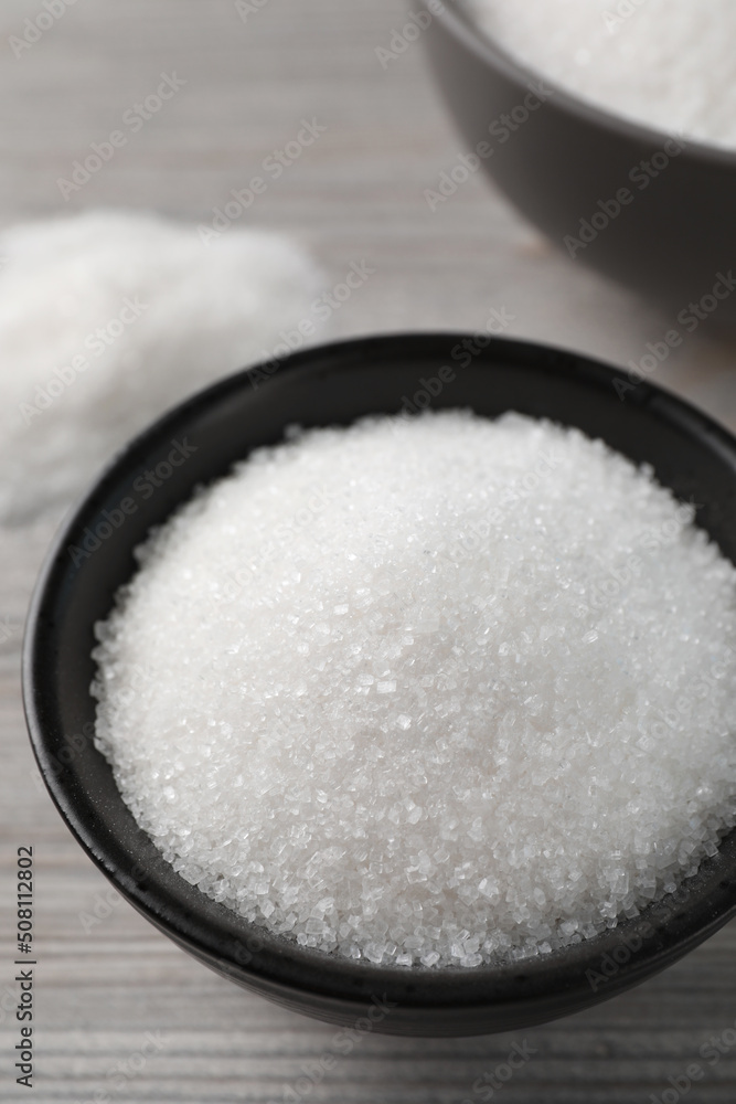 Granulated sugar on light wooden table, closeup Granulated sugar on light wooden table, closeup