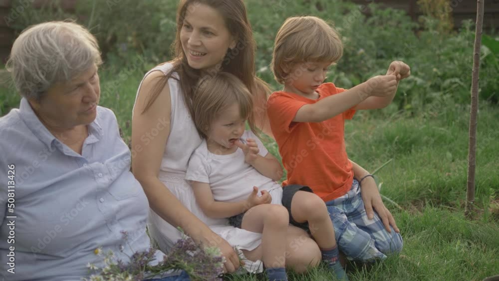 Young woman talk with grandmother, children battle for mother attention, outdoor leisure Young woman talk with grandmother, children battle for mother attention, outdoor leisure
