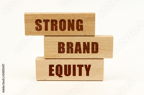 On a white surface are wooden blocks with the inscription - STRONG BRAND EQUITY