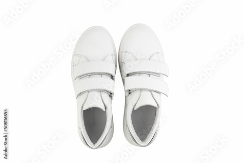 White leather sneakers with velcro in front instead of laces. Isolated close-up on white background. Top view. Fashion shoes.