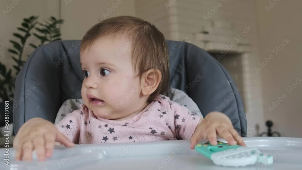 Caucasian baby sitting in a high chair waiting for food. Baby waiting for food. Baby development. Caucasian baby sitting in a high chair waiting for food. Baby waiting for food. Baby development.