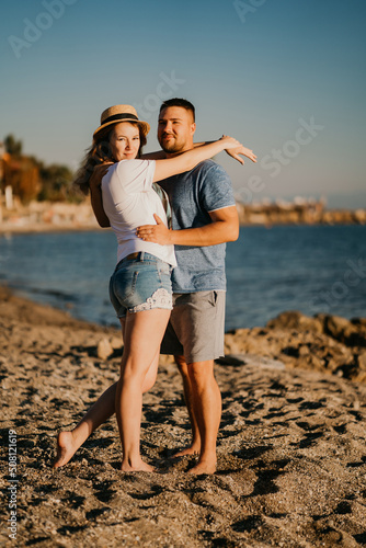 a man and a woman in love hug on the beach. newlyweds at the resort. bright sun. © andrey