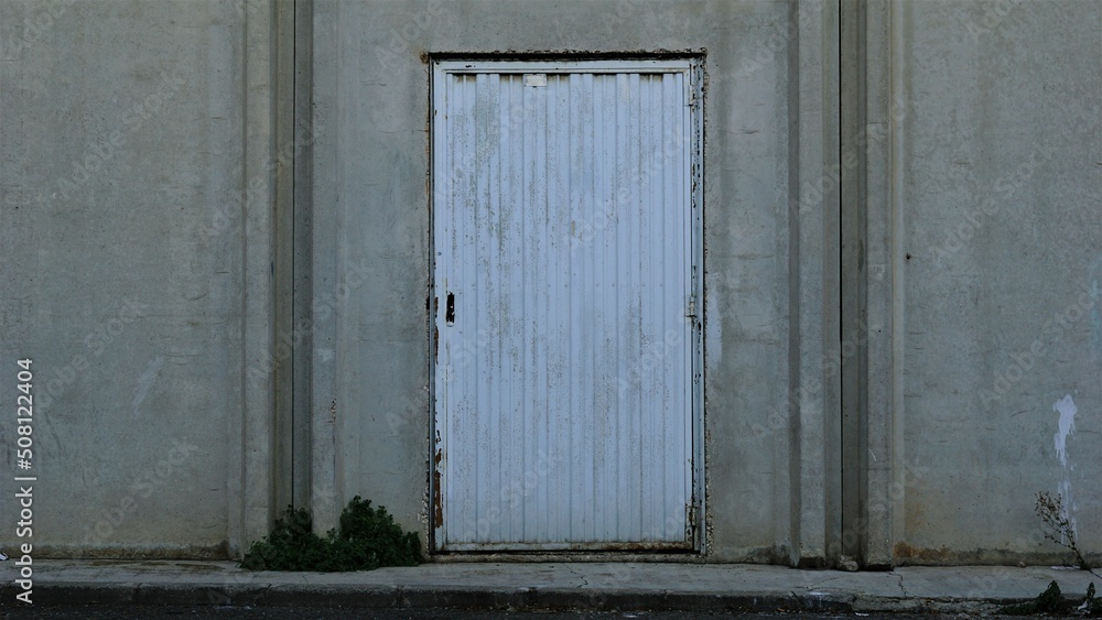 metal door on cement facade sidewalk metal door on cement facade sidewalk