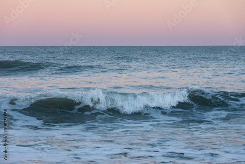 Romantic sunset with pink sky and blue waves in the sea  Walppaper