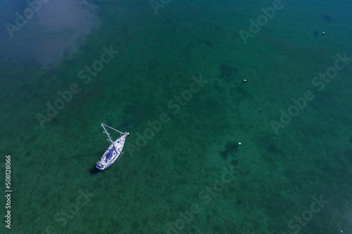 Aerial view on a white yacht in a calm ocean. Travel and tourism concept. Expensive hobby and sport.