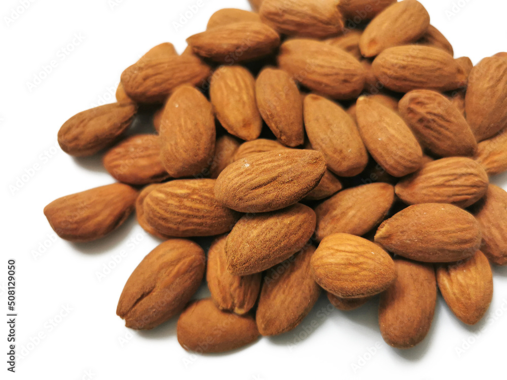 Golden almonds on the white background. Closeup of whole raw almonds Golden almonds on the white background. Closeup of whole raw almonds