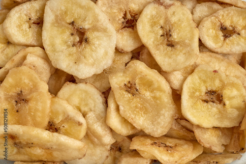 Banana chips background top view. Dried banana slices texture. Heap of dried bananas.