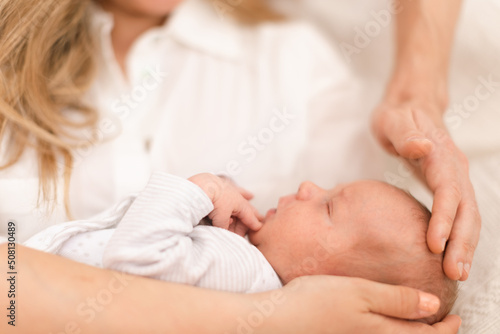Close-up of mother and father holding their newborn baby son at home