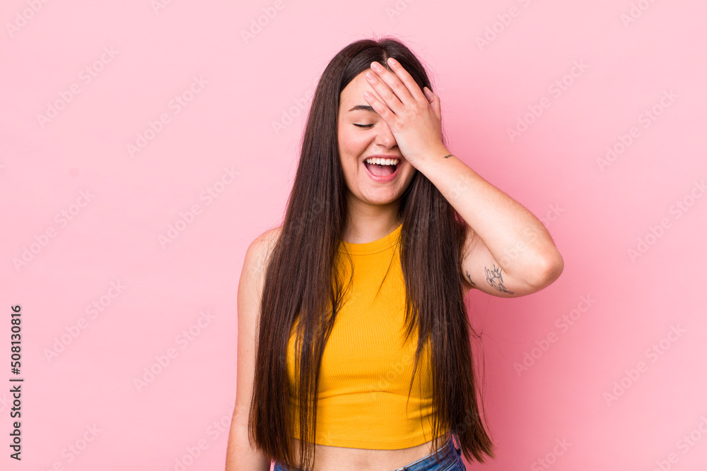 young adult woman laughing and slapping forehead like saying d’oh! I forgot or that was a stupid mistake - obrazy, fototapety, plakaty 