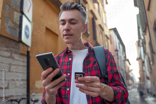 Man in red plaid shirt with a gadget in hands