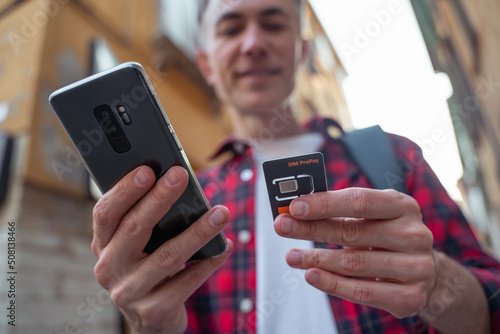 Man in red plaid shirt with a gadget in hands