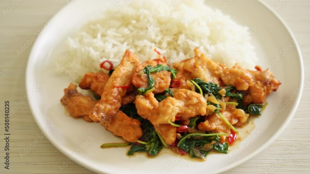stir-fried fried fish with basil and chili in thai style topped on rice - Asian food style stir-fried fried fish with basil and chili in thai style topped on rice - Asian food style