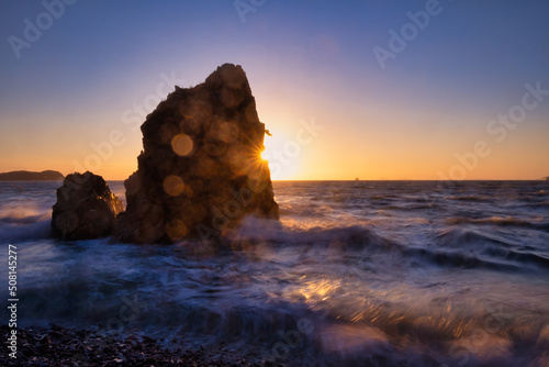 Scenic view of rock and waves during sunset