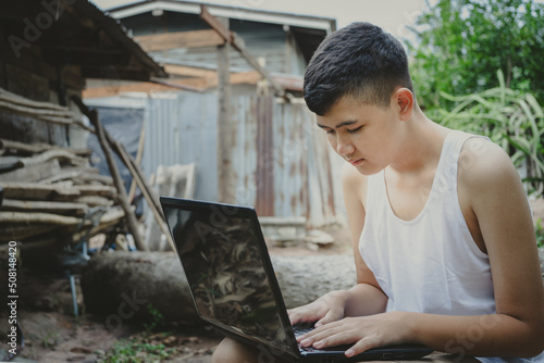 Asian boy studying online with laptop computer on his desk at home countryside, Learning with teacher at home, Homeschooling distance learn online internet rural, poor lack of educational equipment