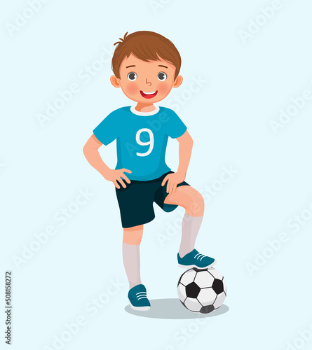 Portrait of cute little boy in sportswear with a soccer ball posing with hand on the waist