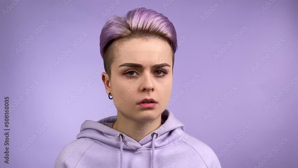 Modern young adult woman turning head left and right gesturing finger on violet color background. Stylish female individuality in trendy hoodie expressing disagreement, denial or rejection. Monochrome Modern young adult woman turning head left and right gesturing finger on violet color background. Stylish female individuality in trendy hoodie expressing disagreement, denial or rejection. Monochrome