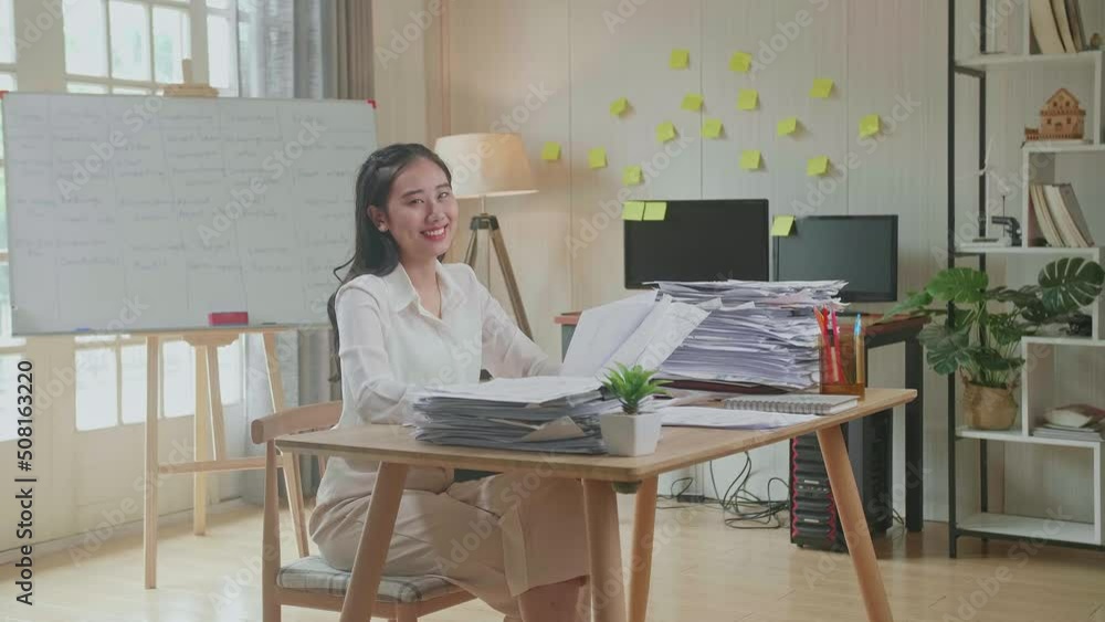 Asian Woman Smiling To Camera While Working With Documents At The Office
Asian Woman Smiling To Camera While Working With Documents At The Office